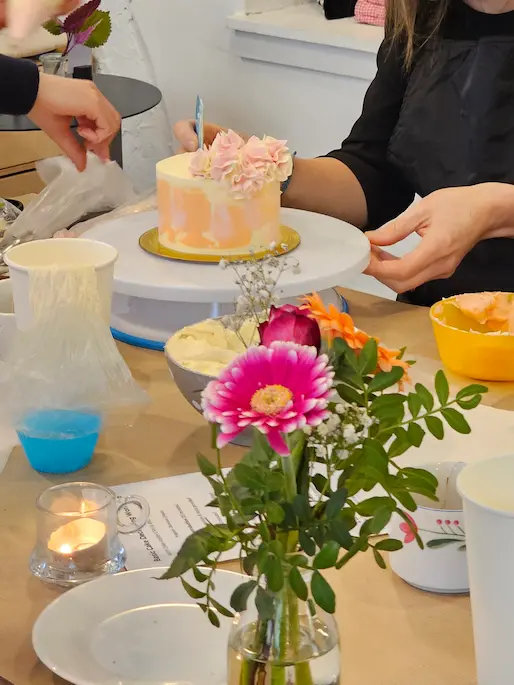 Hands decorating a peach cake